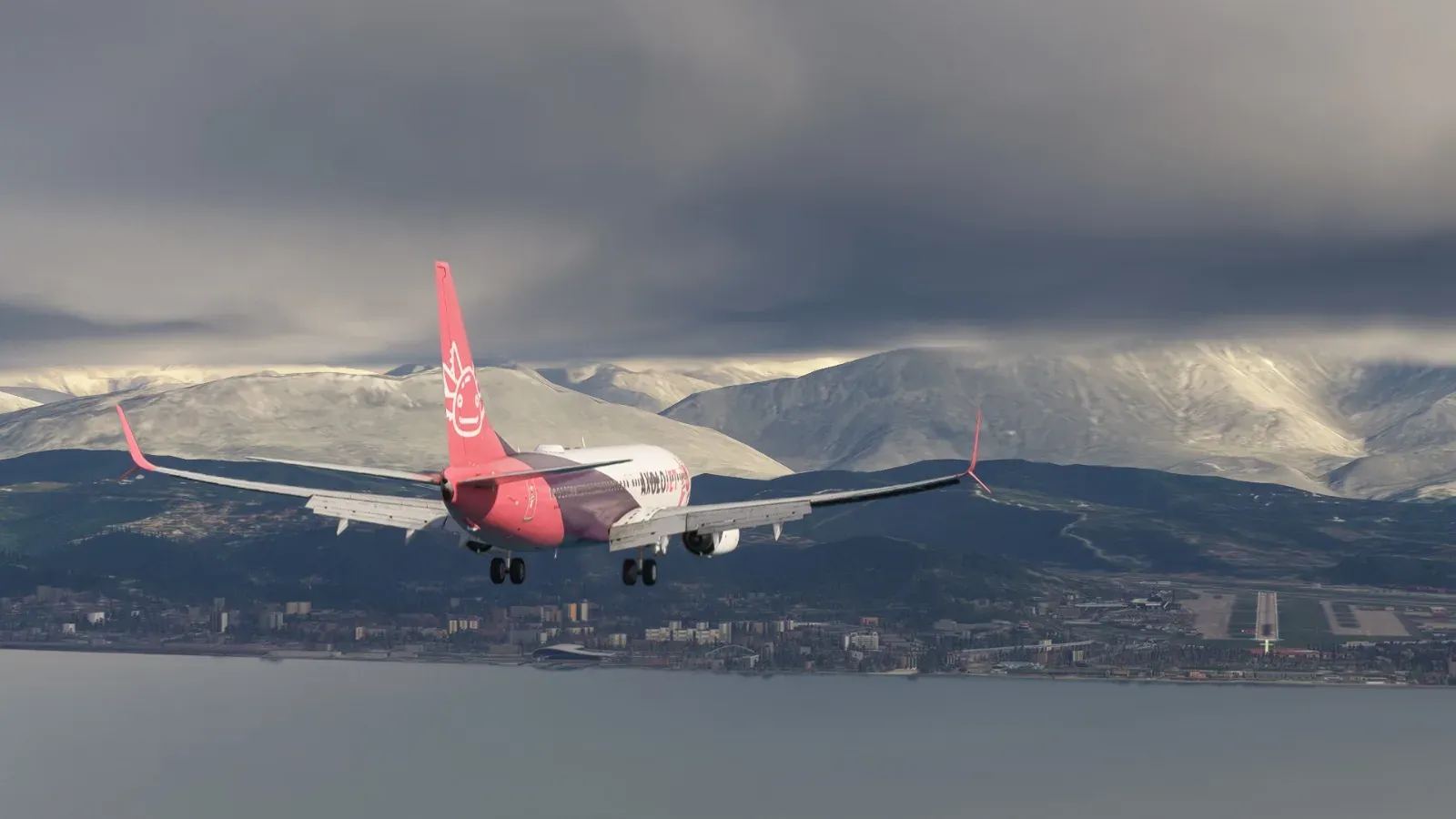 Axolojet Boeing 737 on approach in front of snowy mountains